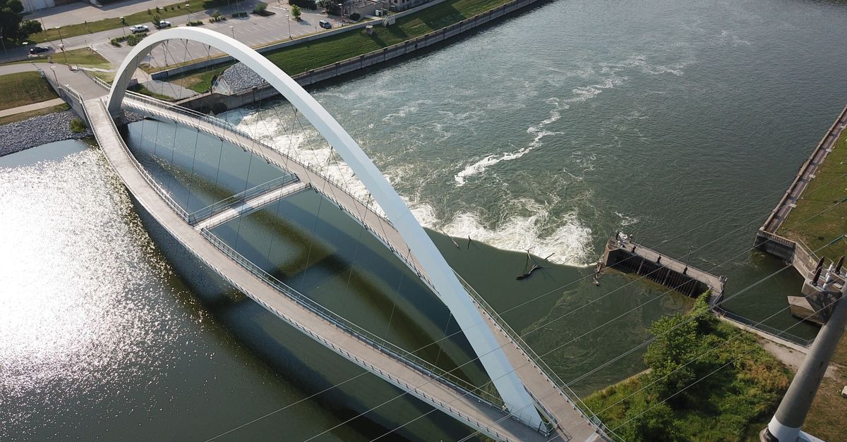 Aerial image capturing a modern bridge over the river in Des Moines, Iowa, USA.