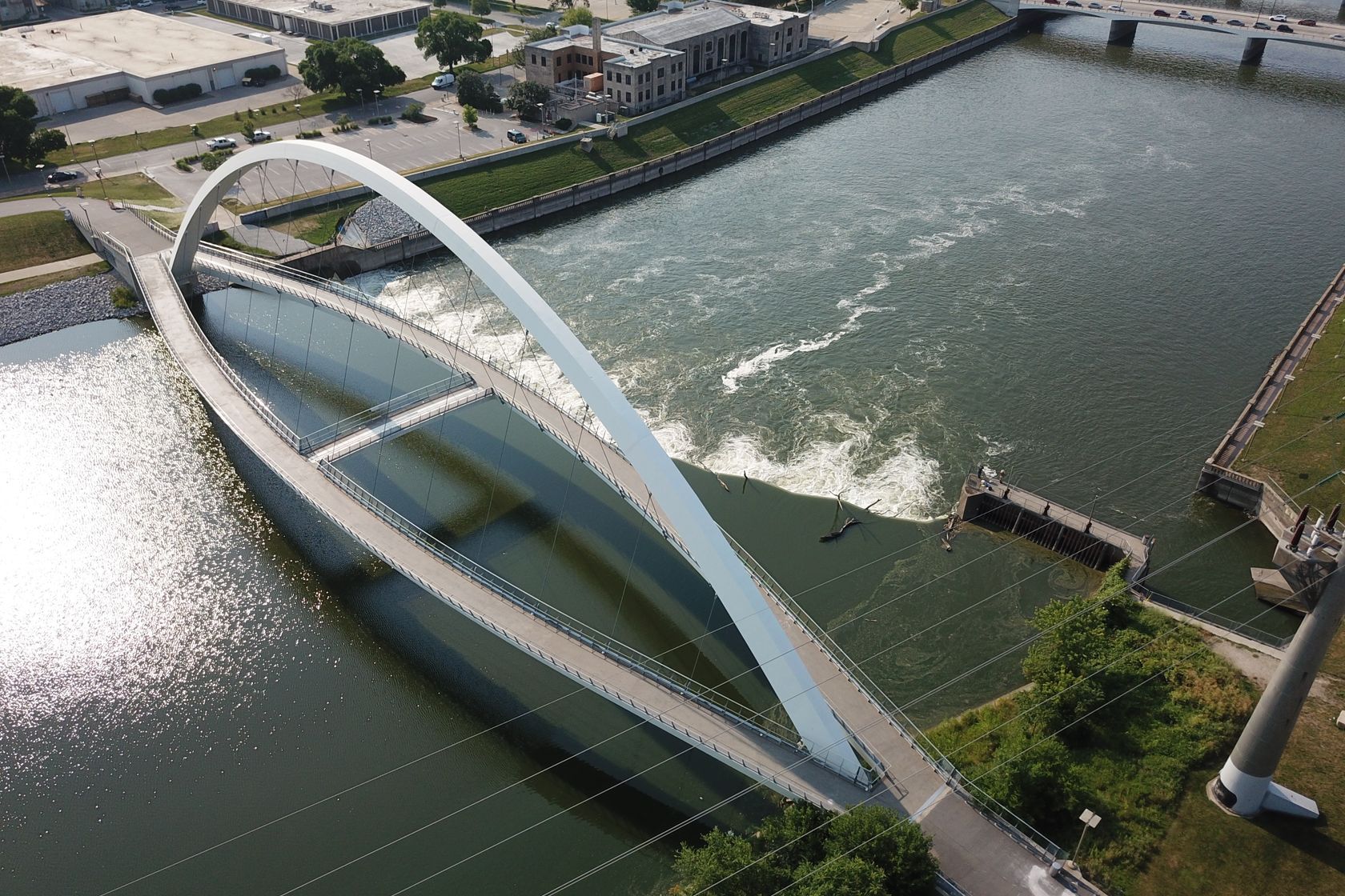 Aerial image capturing a modern bridge over the river in Des Moines, Iowa, USA.