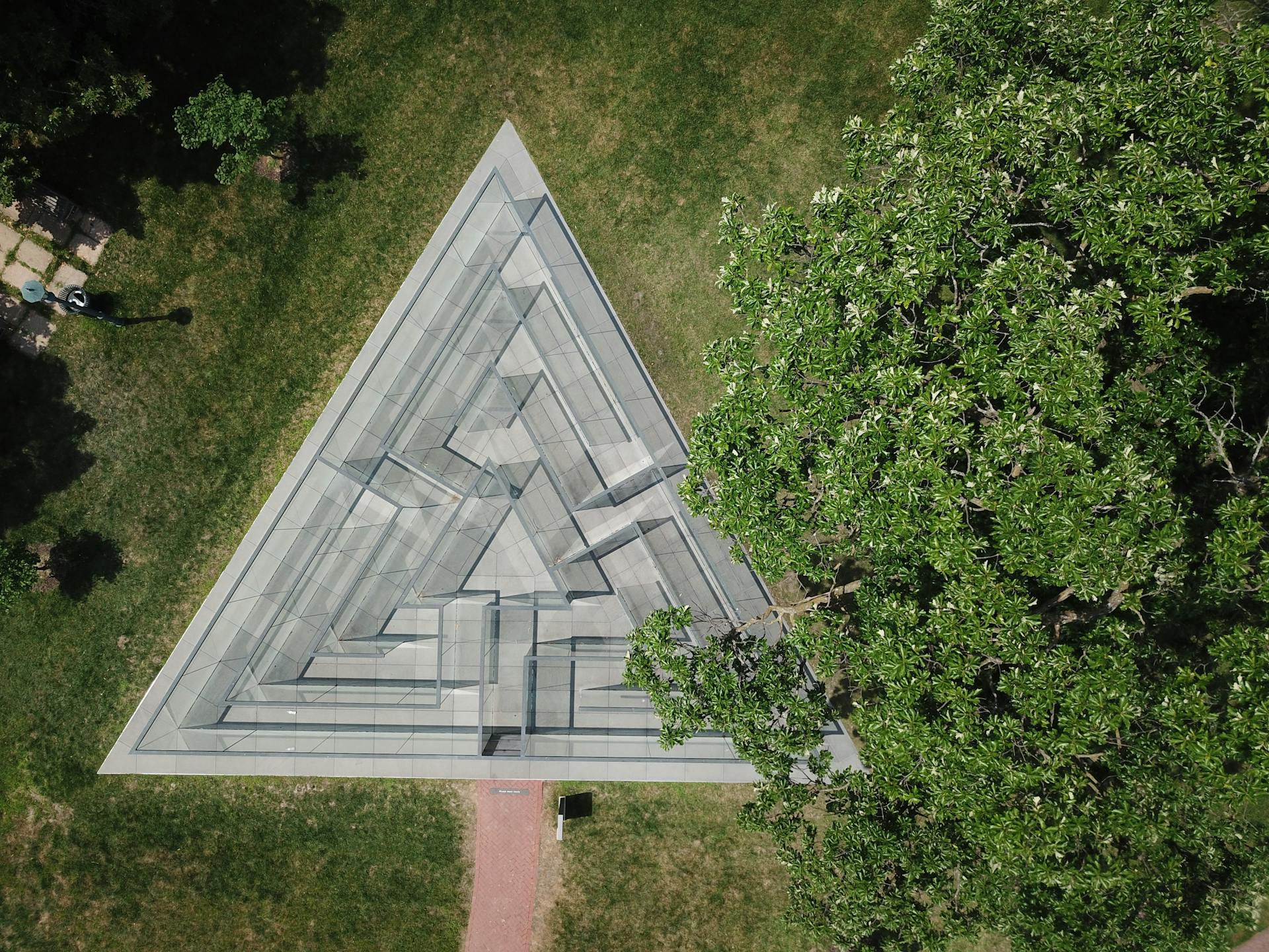 An aerial shot of a triangular glass maze structure in a Kansas City park.