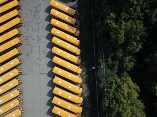Free Aerial shot of yellow school buses lined up next to a forest area in Golden Valley, MN. Stock Photo