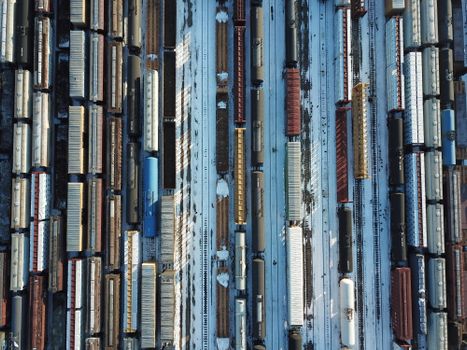 Top-down aerial shot of a train yard covered in snow in Minneapolis, capturing freight trains in winter.