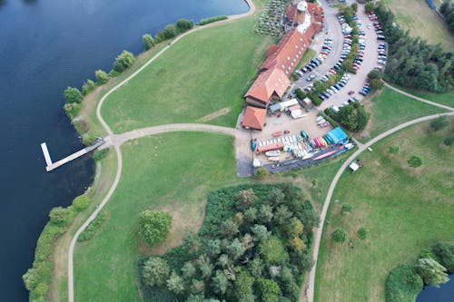 An Aerial Photography of Houses Near Green Grass Field and Body of Water