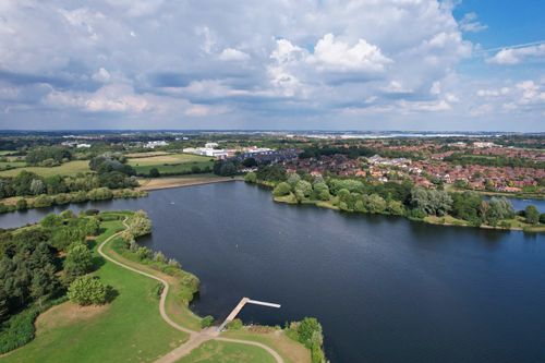Free Aerial photo of Caldecotte Lake, England, showcasing serene water and lush greenery. Stock Photo