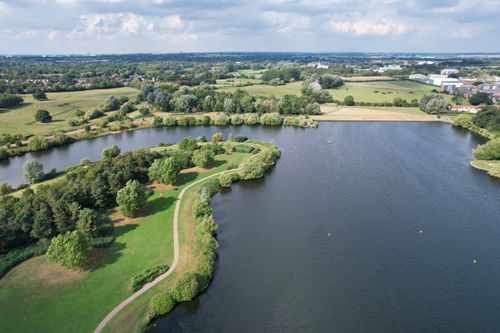 Free Scenic aerial view of calm lake and lush green countryside in Milton Keynes, England. Stock Photo