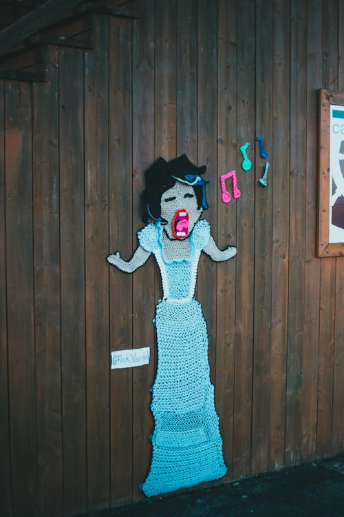 Free A Crochet of a Singing Woman Posted on a Wooden Wall Stock Photo