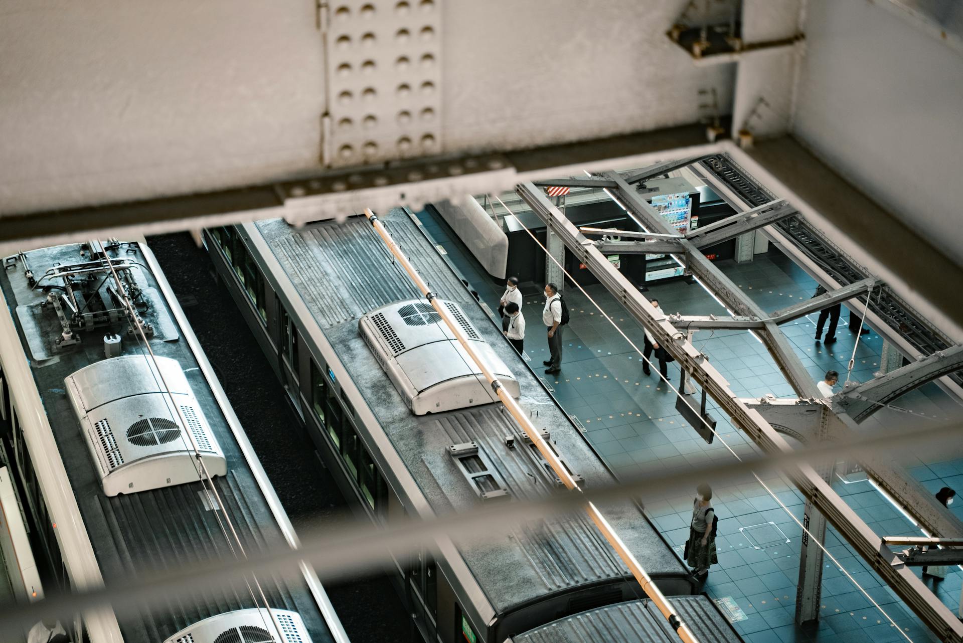 Aerial view of a train station platform in Osaka, Japan with waiting passengers.