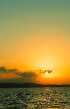 A stunning ocean sunset with vibrant hues of orange and yellow over calm waters.