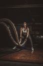 Woman in Black Brassiere and Black Panty Sitting on Brown Rope