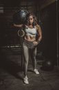 Woman in White Sports Bra and Black Leggings Standing Beside Black Wall