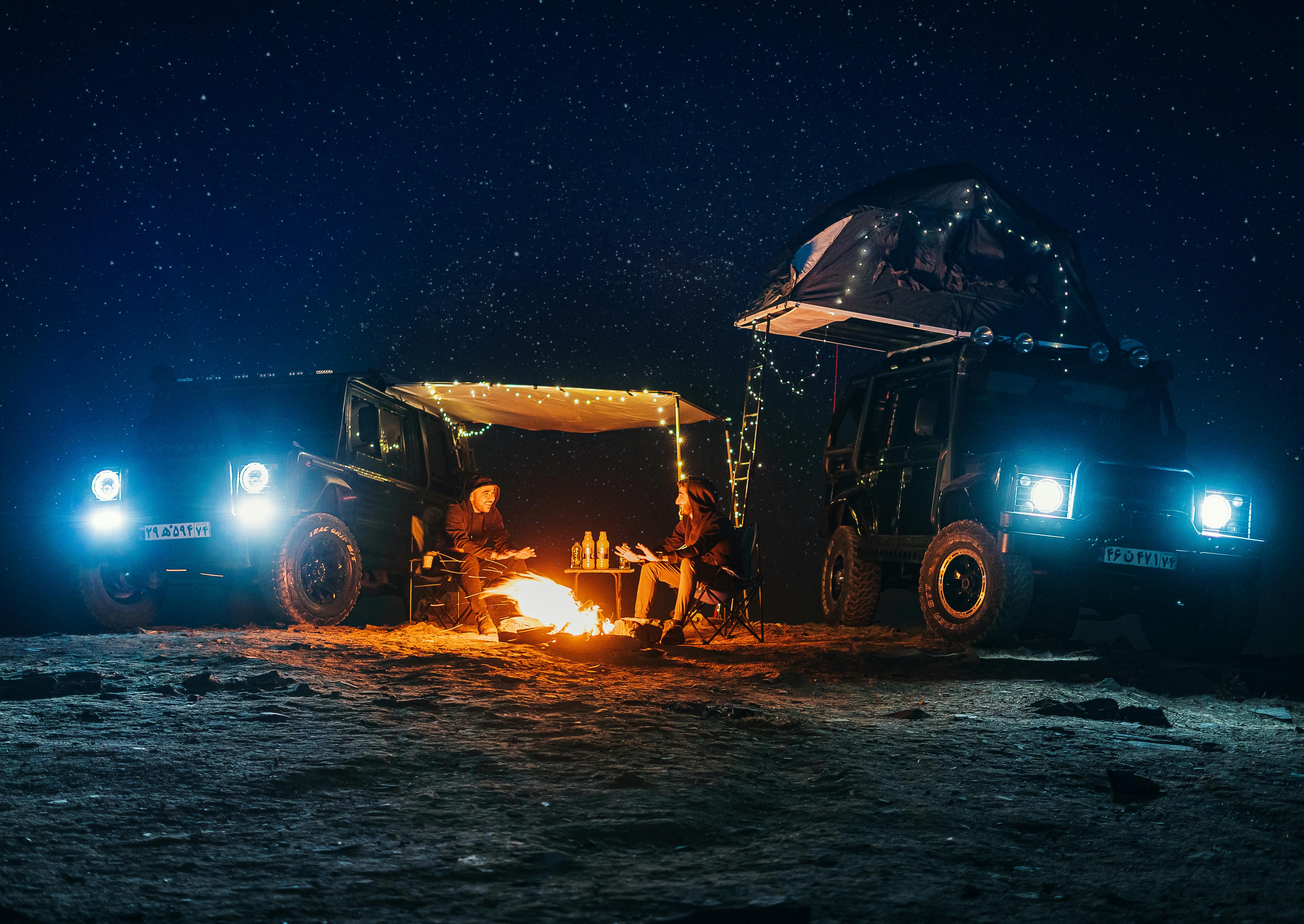 men sitting by the campfire under a starry night sky