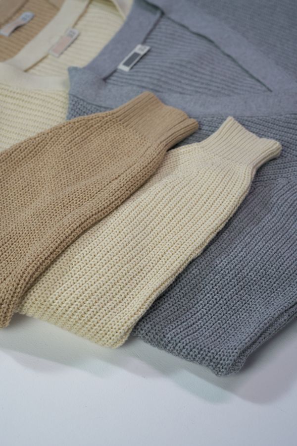 Folded knit sweaters in earthy tones — photo by Ron Lach on Pexels