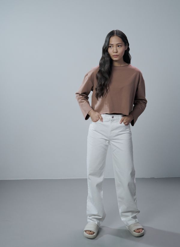 Tan crewneck sweater with high-waisted jeans and sneakers