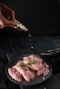 Person Holding Stainless Steel Fork and Knife Slicing Meat on Black Round Plate
