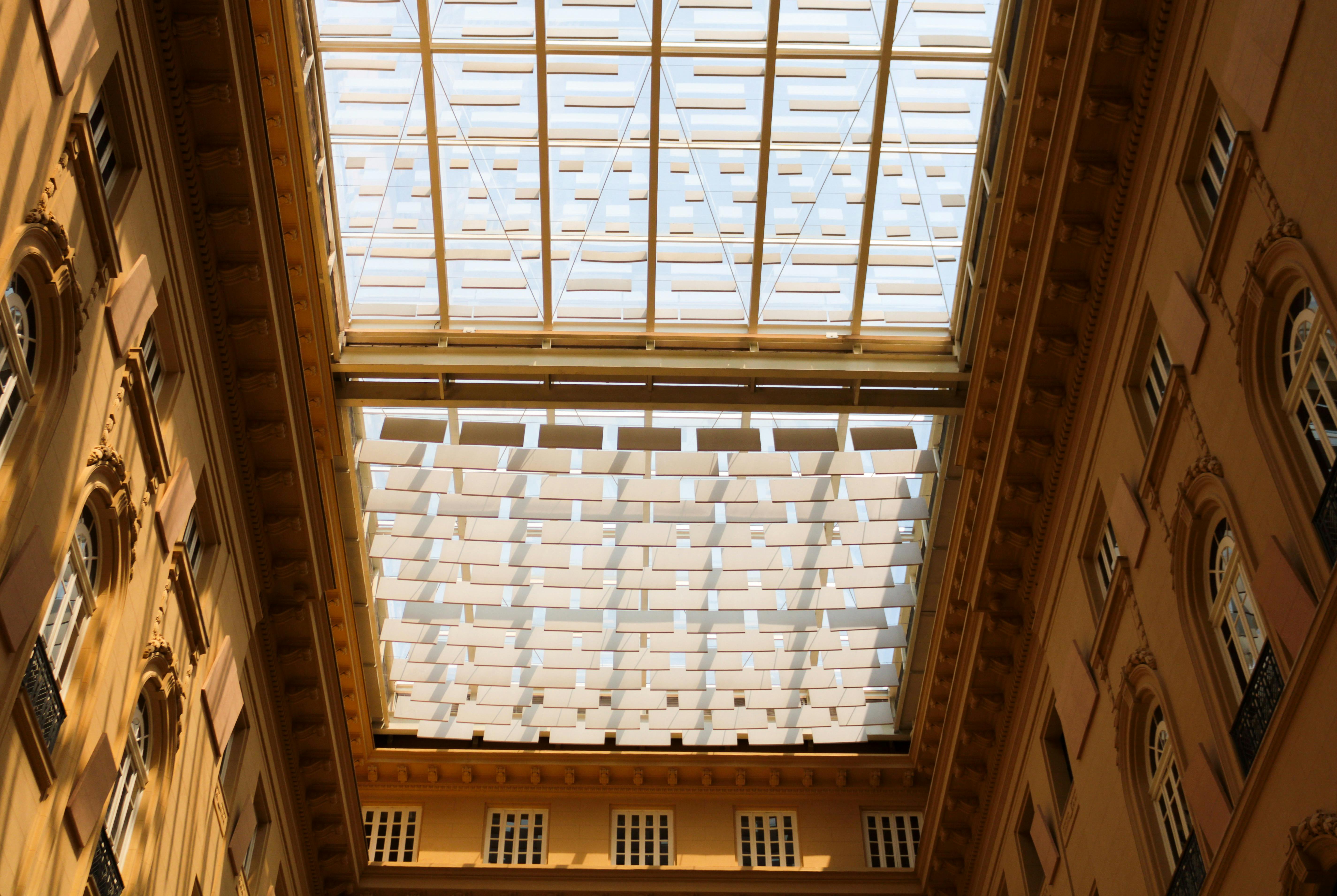 A low angle shot of a modern building's glass skylight and courtyard. Architectural details visible.