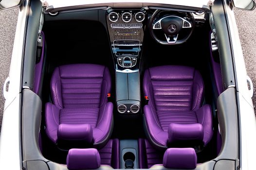Overhead view of a Mercedes-Benz interior featuring striking purple leather seats and modern cockpit design.