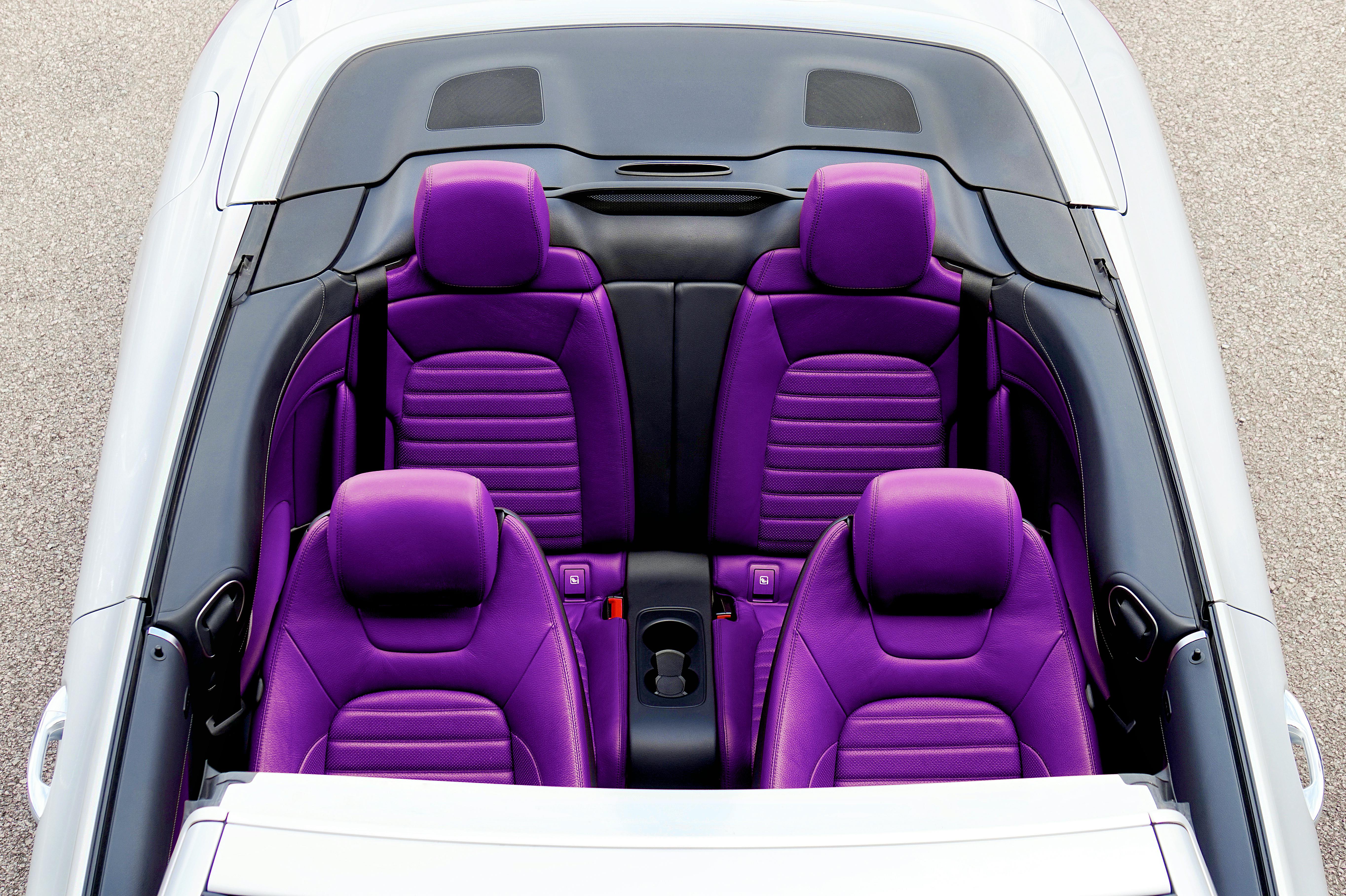 Top view of a luxurious convertible car featuring vibrant purple leather seats.