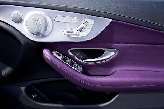 Close-up of a Mercedes-Benz E-Class door panel featuring purple leather and luxury controls.