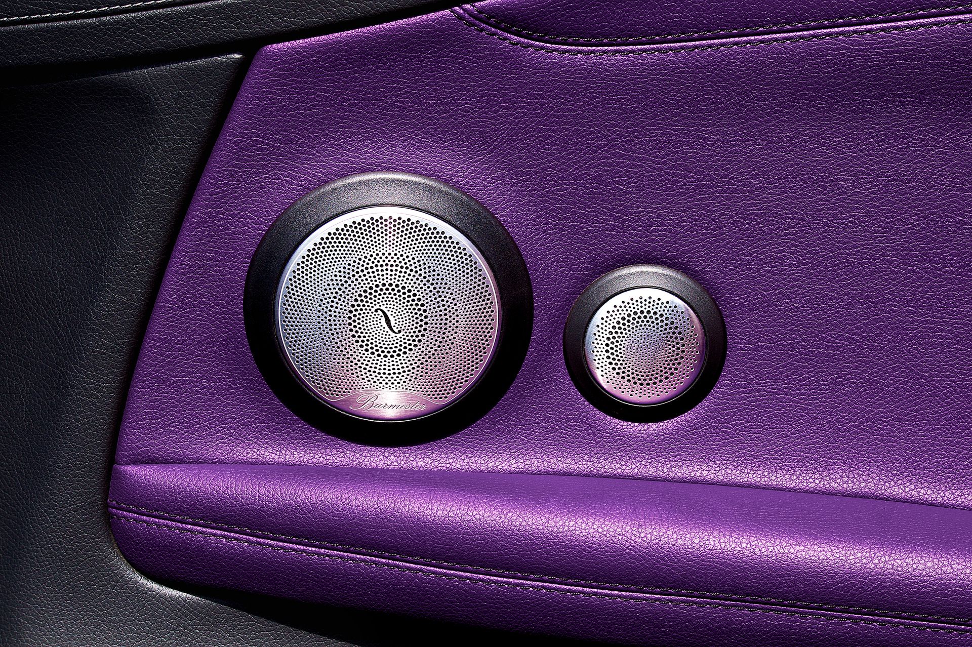 Detailed view of premium car speakers with purple leather accents