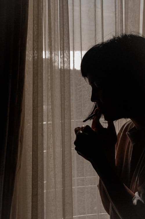 Free Silhouette of a Woman Smoking a Cigarette Stock Photo