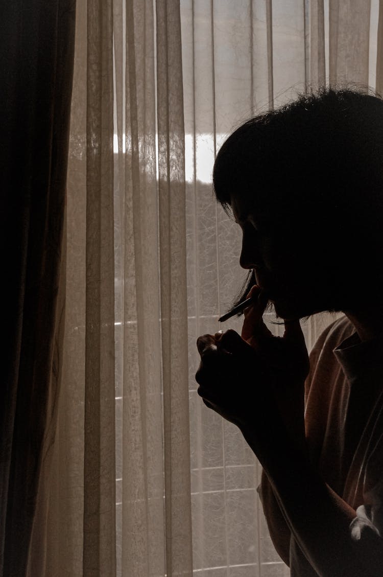 Silhouette Of A Woman Smoking A Cigarette