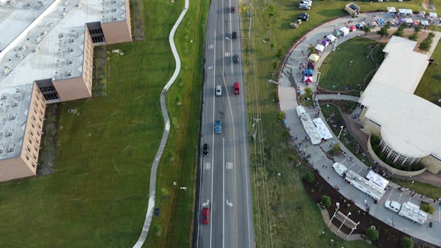 Aerial shot of a road, buildings, and a park in Royse City, Texas, showcasing urban life.