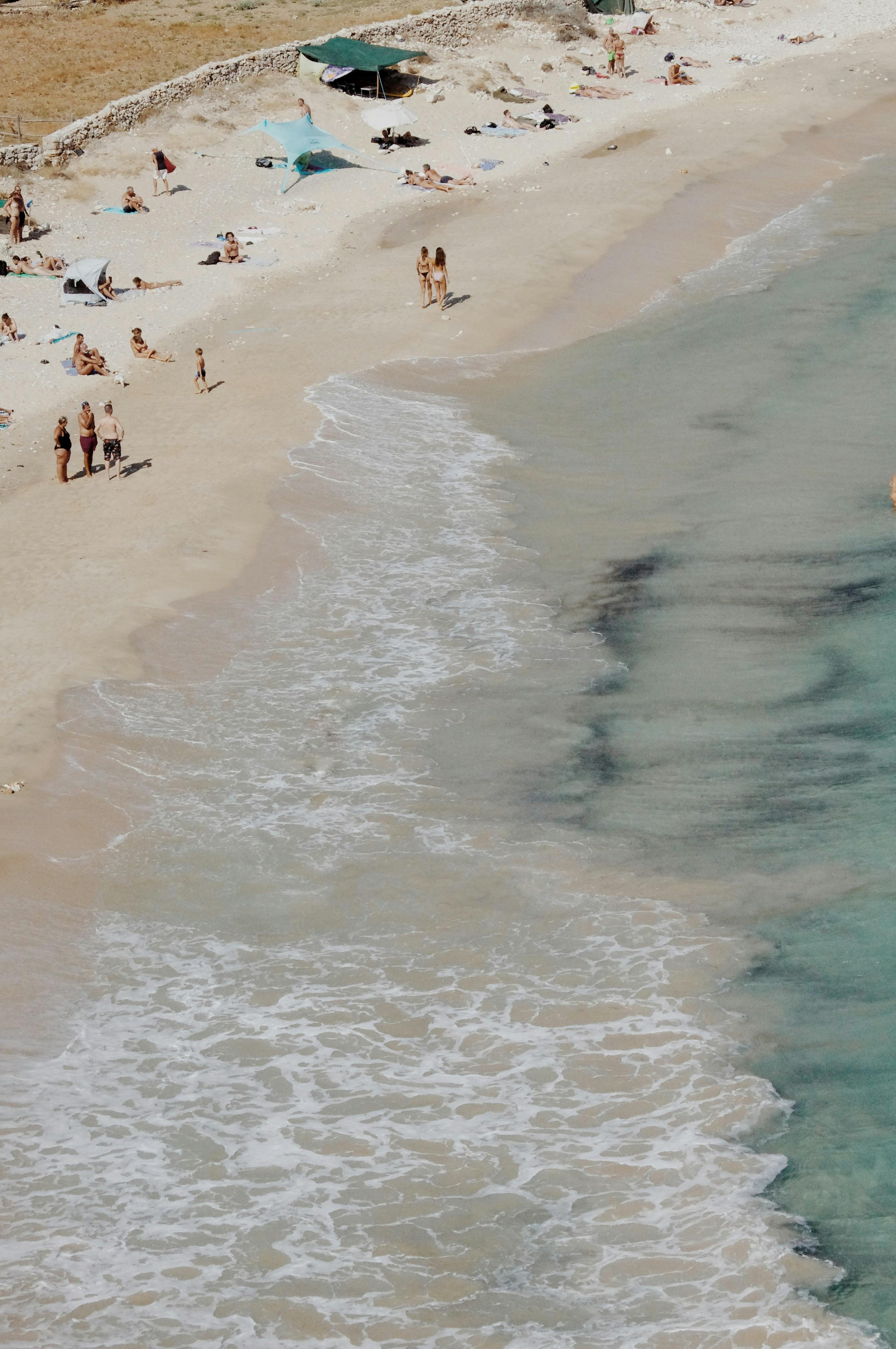 A beautiful aerial shot of Donoussa beach with people sunbathing and enjoying the sea.