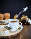 White Ceramic Teacup on Saucer Beside Stainless Steel Spoon