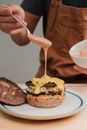 Man adding sauce to hamburger