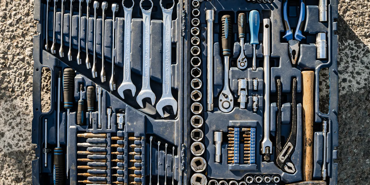 A flat lay of an organised toolbox with hand tools laid out in rows, illustrating the growing kit of AI search optimization tools