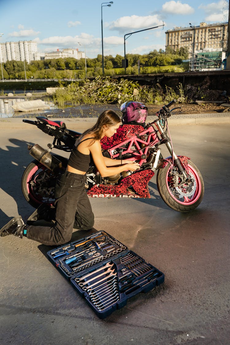 Woman Fixing A Motorcycle