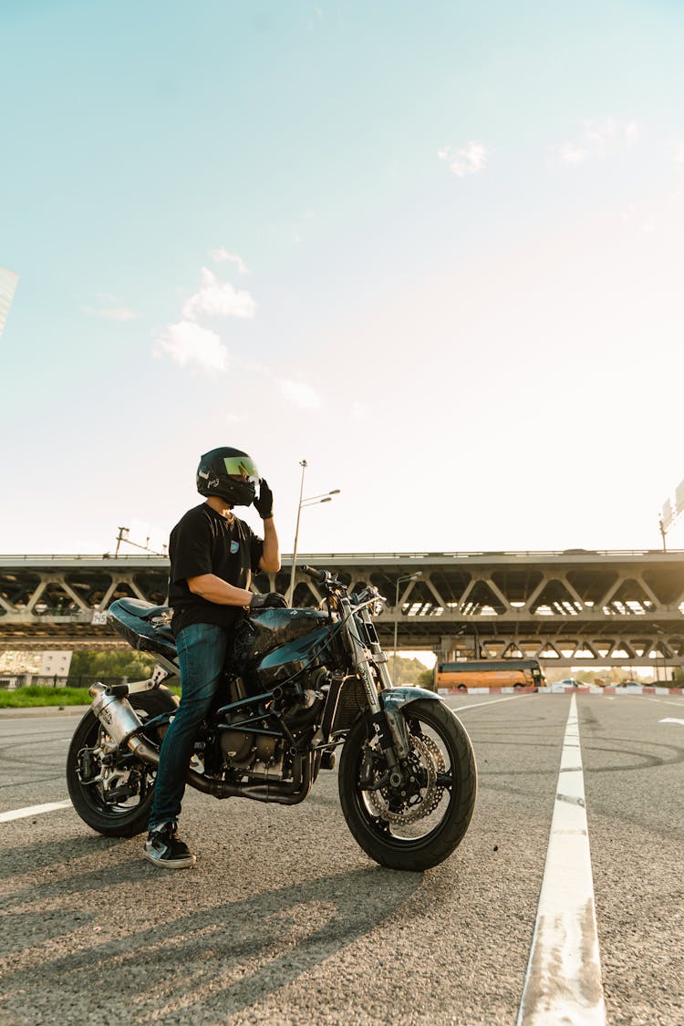 Close-Up Shot Of A Man Riding A Black Motorcycle