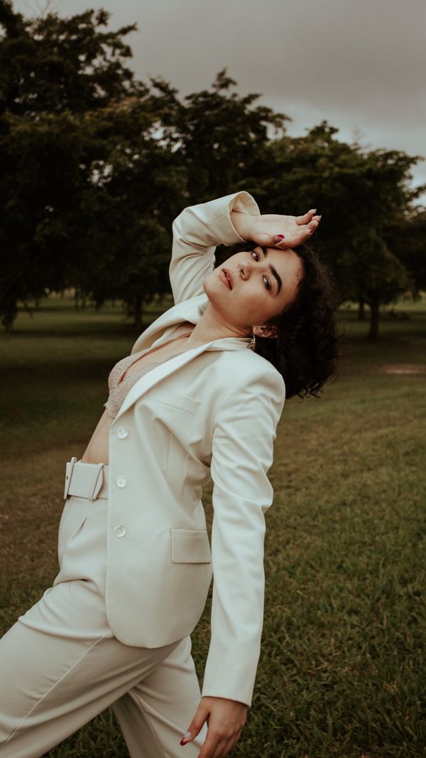 Woman in a white linen blazer and wide-leg trousers