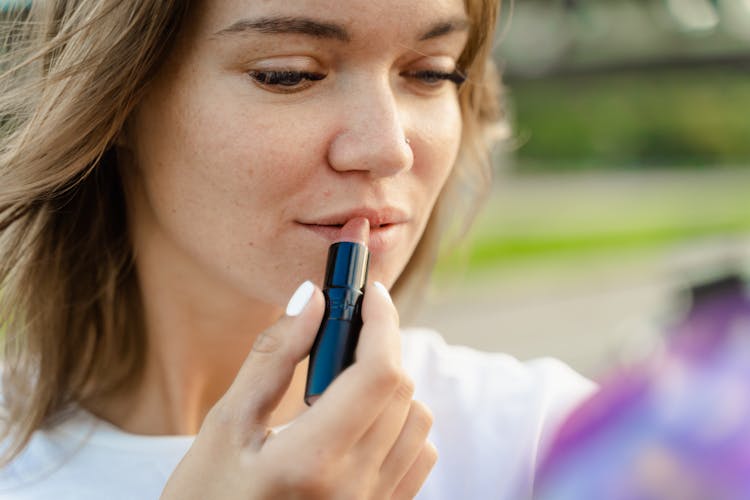 Close Up Photo Of Woman Applying Lipstick On Her Lips