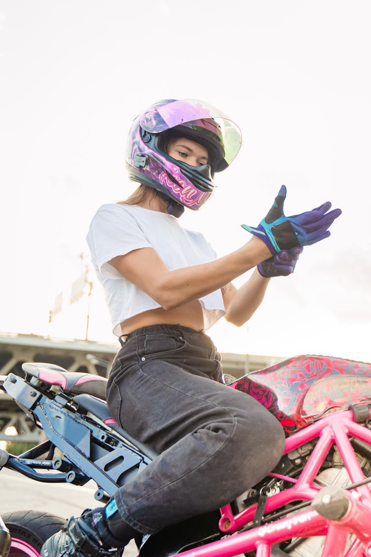 A Woman Wearing Helmet Putting On Hand Gloves