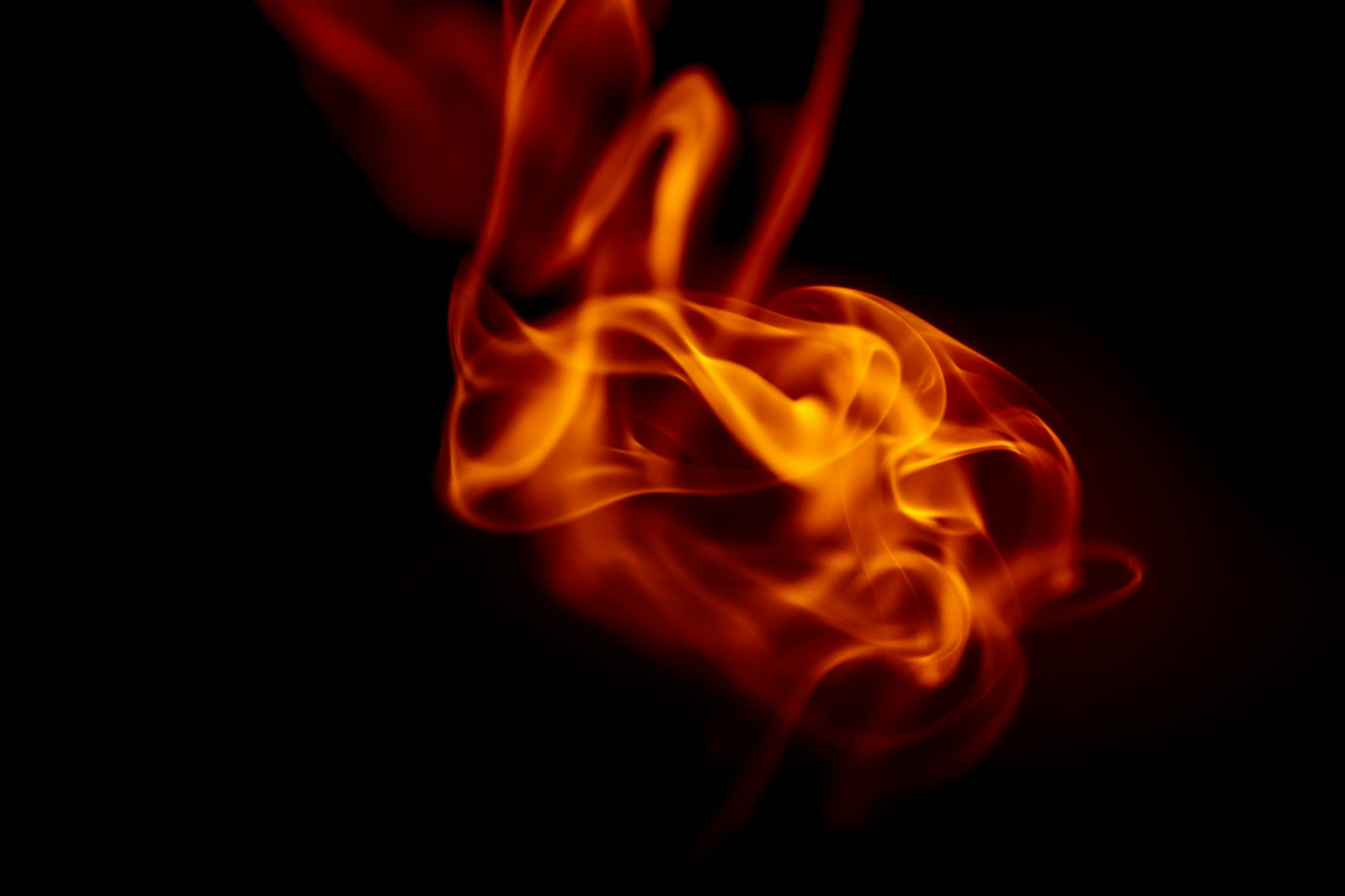 A vivid close-up of swirling flames against a dark background, capturing dynamic movement and heat.