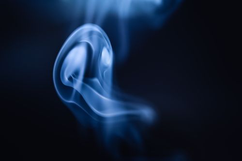 Free A captivating abstract image of swirling blue smoke set against a dark background. Stock Photo
