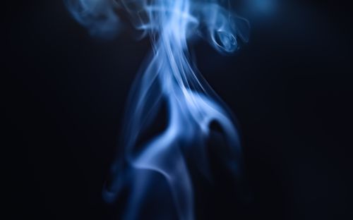Free Ethereal blue smoke rising in a dark, mystical setting, creating a sense of mystery and calm. Stock Photo
