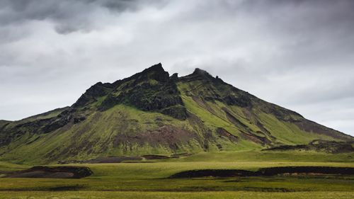 Free A stunning view of a lush green mountain against a gloomy sky in Iceland. Stock Photo