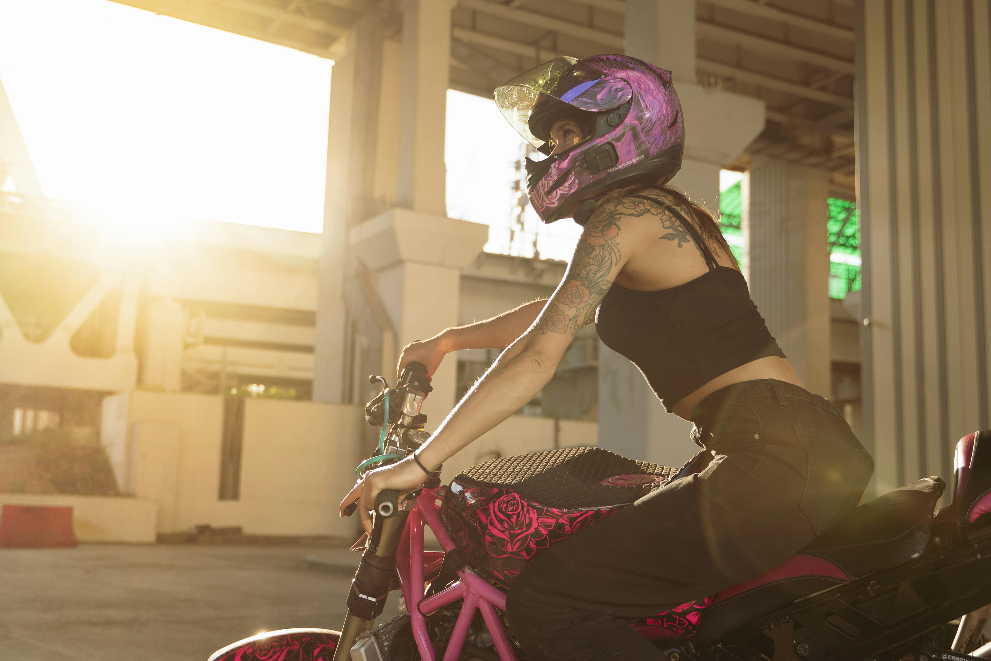 close up shot of a woman riding a motorycle during sunset