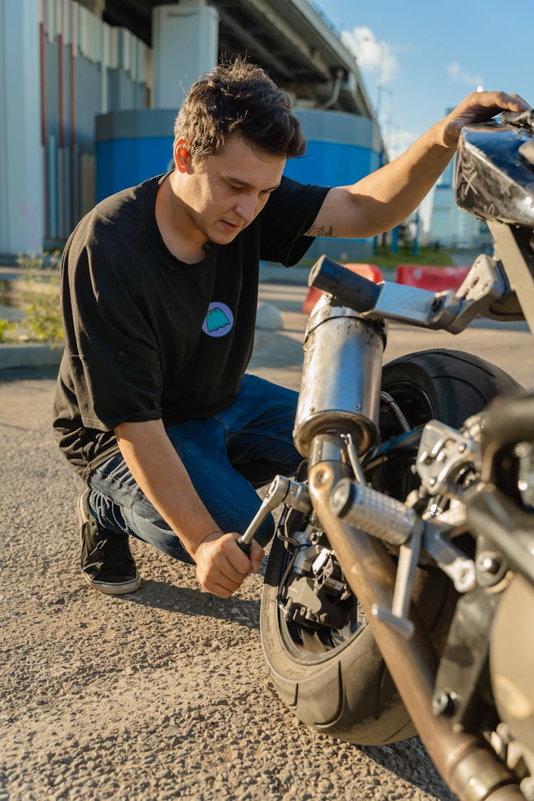 Man In Black Shirt Fixing A Motor 