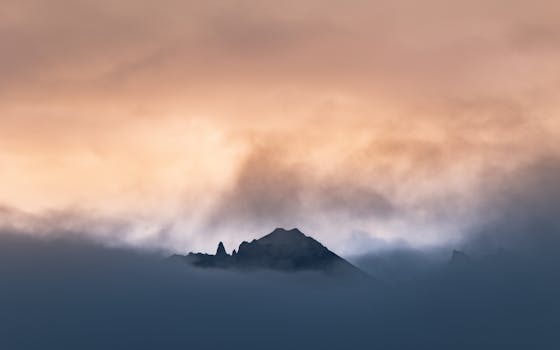 Capture of misty mountain peaks against a dramatic Icelandic sunrise.