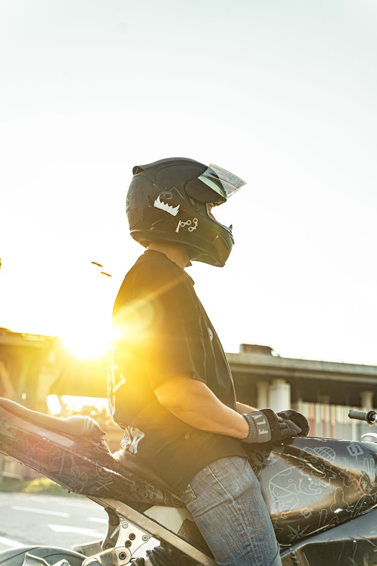 Close-Up Shot Of A Man Riding A Motorcycle During Sunset