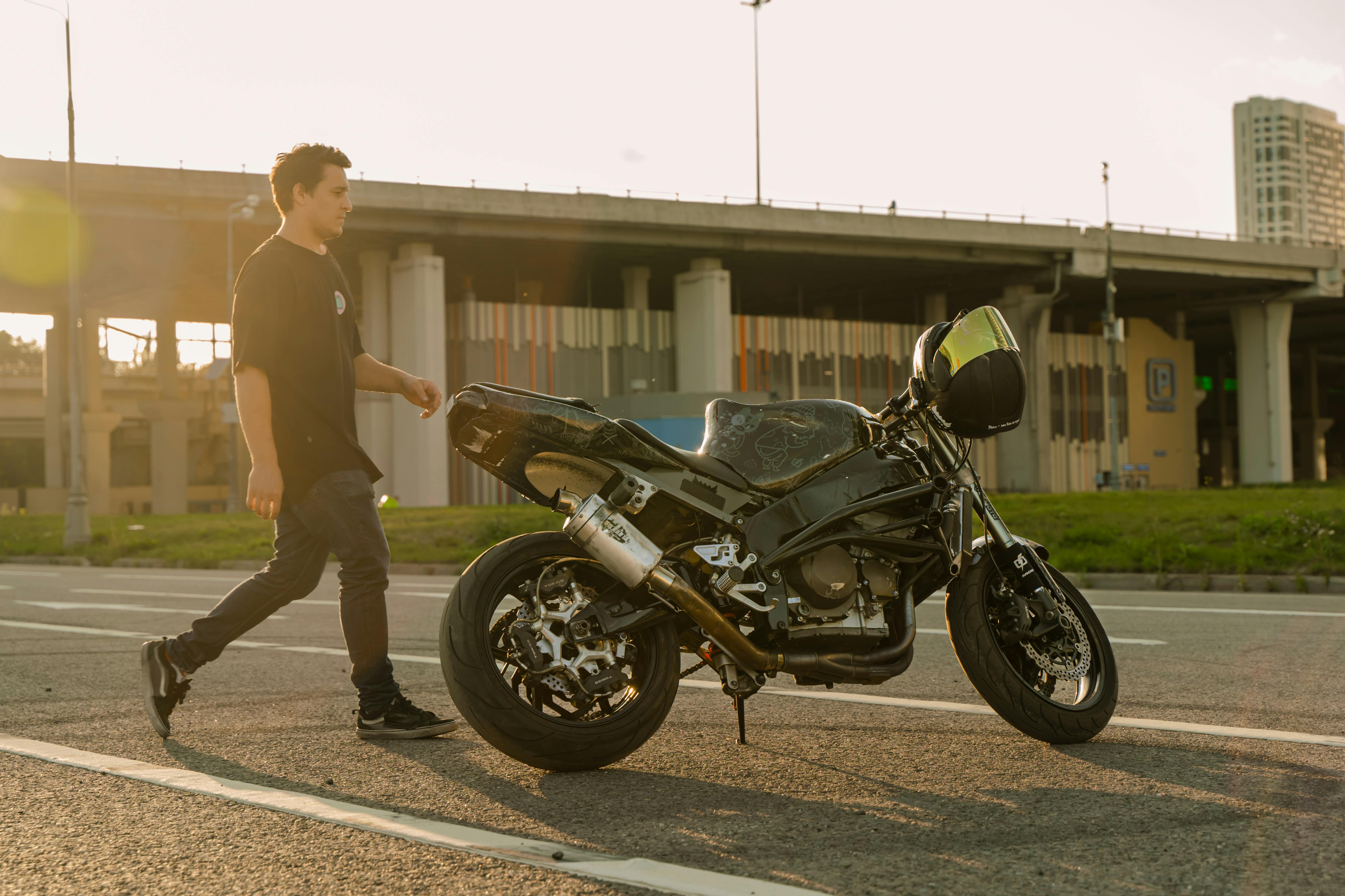 a man walking towards a parked motorcycle