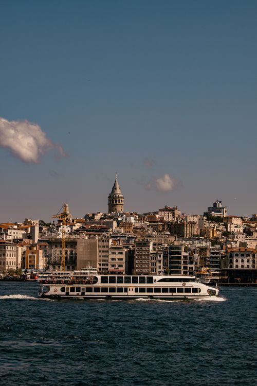 Free Bosphorus ferry cruising with a view of historic Istanbul and Galata Tower under a blue sky. Stock Photo