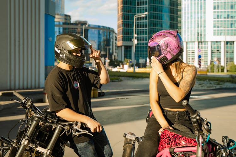 Man And Woman On Motorcycles With Helmets