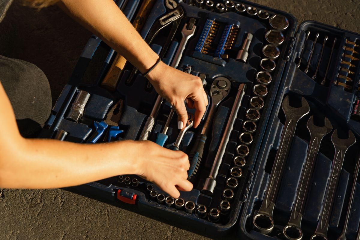 Mechanic's hands organizing a complete socket and ratchet tool case for garage maintenance