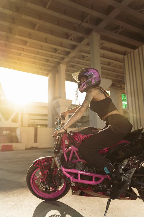 Free A Woman Wearing a Helmet Sitting on a Parked Motorcycle Stock Photo