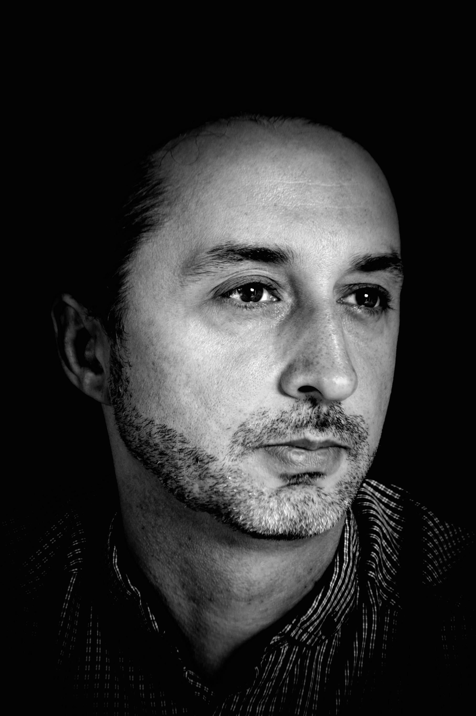 grayscale photo of a man on plain black background