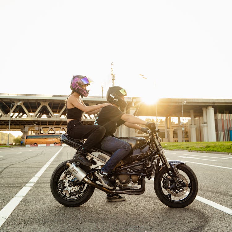 A Man And A Woman Riding A Motorcycle