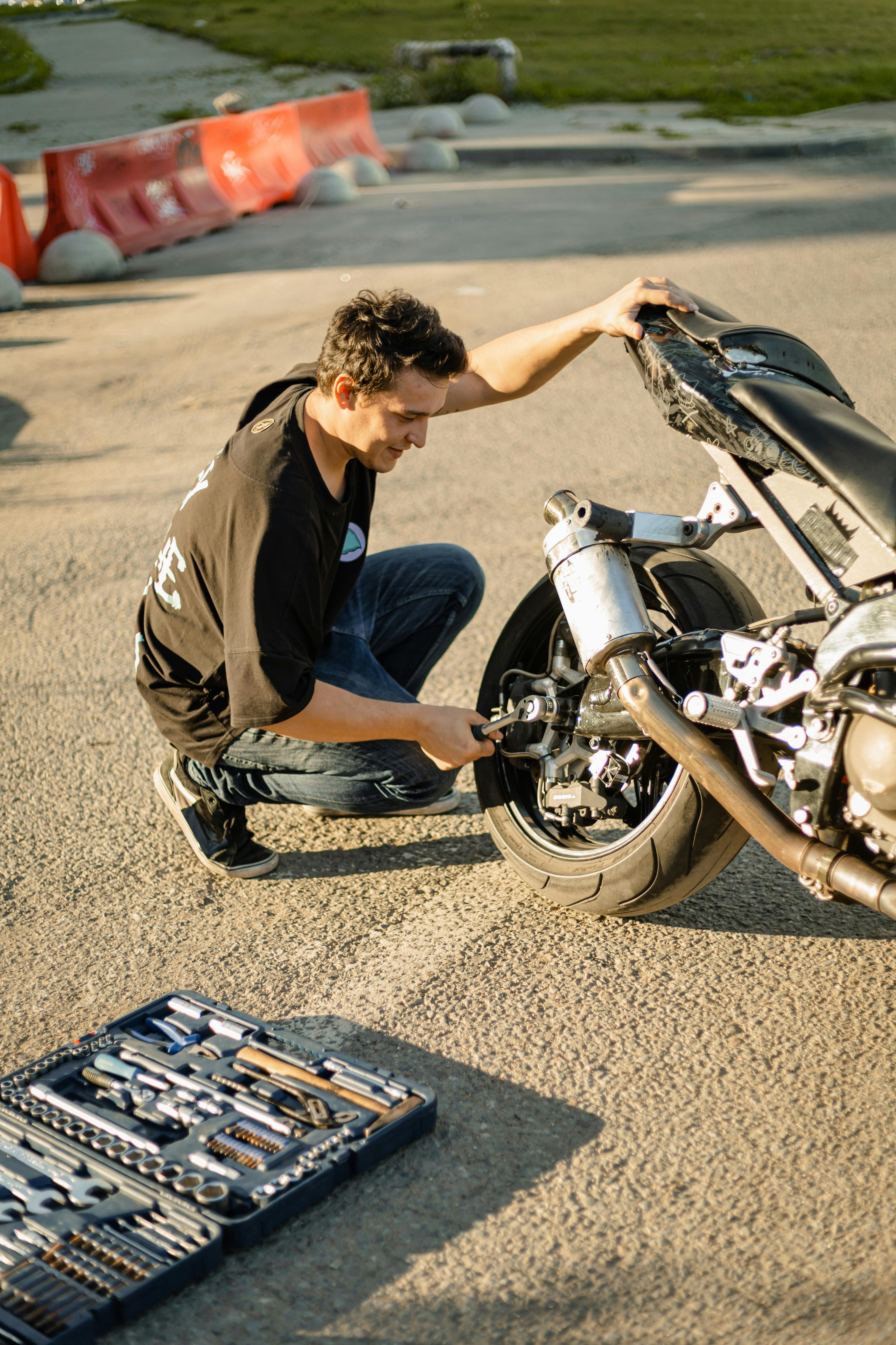 CloseUp Shot of a Person Fixing an Engine of a Motorcycle · Free Stock